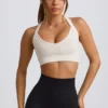 Bezszwowy biustonosz sportowy Super Sculpt z krzyżującymi się na plecach ramiączkami w kolorze białym Bezszwowy biustonosz sportowy Super Sculpt z krzyżującymi się na plecach ramiączkami w kolorze białym