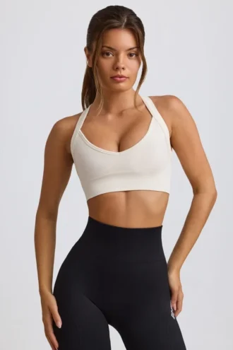 Bezszwowy biustonosz sportowy Super Sculpt z krzyżującymi się na plecach ramiączkami w kolorze białym Bezszwowy biustonosz sportowy Super Sculpt z krzyżującymi się na plecach ramiączkami w kolorze białym