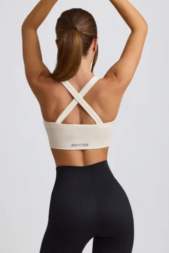 Bezszwowy biustonosz sportowy Super Sculpt z krzyżującymi się na plecach ramiączkami w kolorze białym Bezszwowy biustonosz sportowy Super Sculpt z krzyżującymi się na plecach ramiączkami w kolorze białym
