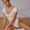 Body z panelami i odkrytymi plecami w kolorze delikatnej bieli Body z panelami i odkrytymi plecami w kolorze delikatnej bieli