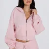 Krótka bluza z kapturem z miękkiej dzianiny w kolorze delikatnego różu Krótka bluza z kapturem z miękkiej dzianiny w kolorze delikatnego różu