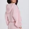 Krótka bluza z kapturem z miękkiej dzianiny w kolorze delikatnego różu Krótka bluza z kapturem z miękkiej dzianiny w kolorze delikatnego różu