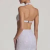 Lucia – ozdobna mini sukienka z wycięciami i wiązaniem na szyi w kolorze białym