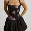 Mini sukienka Nanala z wiązaniem na szyi i falbanowym dołem w czarny kwiatowy wzór Mini sukienka Nanala z wiązaniem na szyi i falbanowym dołem w czarny kwiatowy wzór