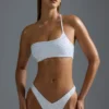Oh Polly Moda kąpielowa: Top bikini bandeau z jednym ramiączkiem z ozdobami z serii HOTFIX w kolorze białym Oh Polly Moda kąpielowa: Top bikini bandeau z jednym ramiączkiem z ozdobami z serii HOTFIX w kolorze białym
