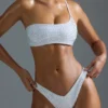 Oh Polly Moda kąpielowa: Top bikini bandeau z jednym ramiączkiem z ozdobami z serii HOTFIX w kolorze białym Oh Polly Moda kąpielowa: Top bikini bandeau z jednym ramiączkiem z ozdobami z serii HOTFIX w kolorze białym