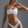 Oh Polly Moda kąpielowa: Top bikini bandeau z jednym ramiączkiem z ozdobami z serii HOTFIX w kolorze białym Oh Polly Moda kąpielowa: Top bikini bandeau z jednym ramiączkiem z ozdobami z serii HOTFIX w kolorze białym