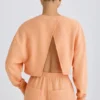 Teksturowana bawełniana bluza z odkrytymi plecami w kolorze brzoskwiniowym Teksturowana bawełniana bluza z odkrytymi plecami w kolorze brzoskwiniowym