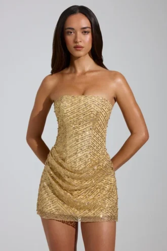 Złota mini sukienka Amalina z ozdobami w stylu bandeau i krojem w kształcie litery A Złota mini sukienka Amalina z ozdobami w stylu bandeau i krojem w kształcie litery A